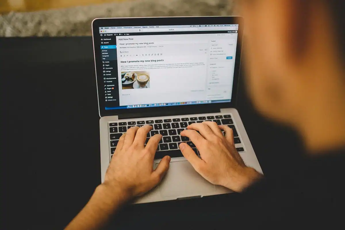 Bărbat concentrat care scrie la laptop într-un birou amenajat acasă