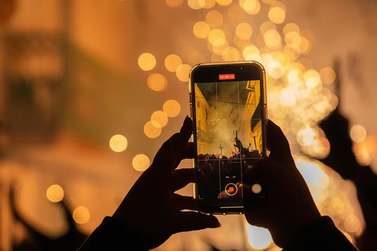 Smartphone montat pe trepied pe un birou, setup simplu de filmare pentru un canal de YouTube mic