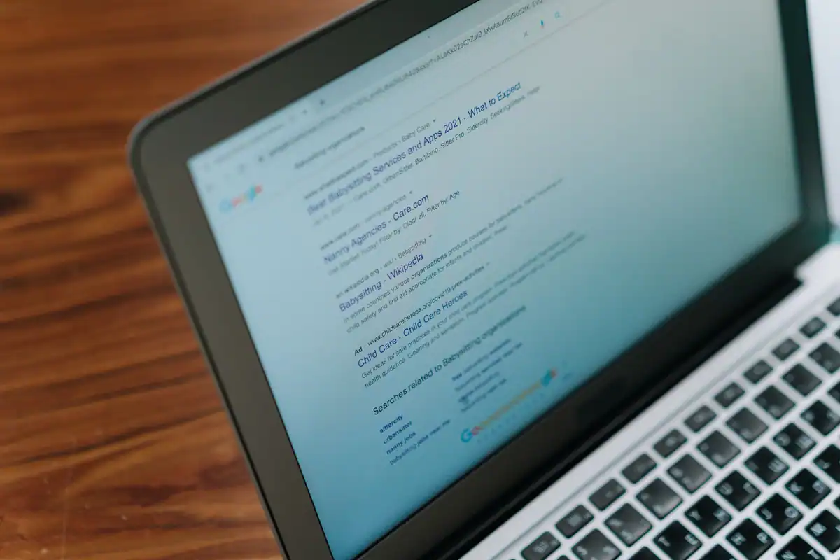 Laptop pe un birou de lemn cu o pagină web deschisă în browser