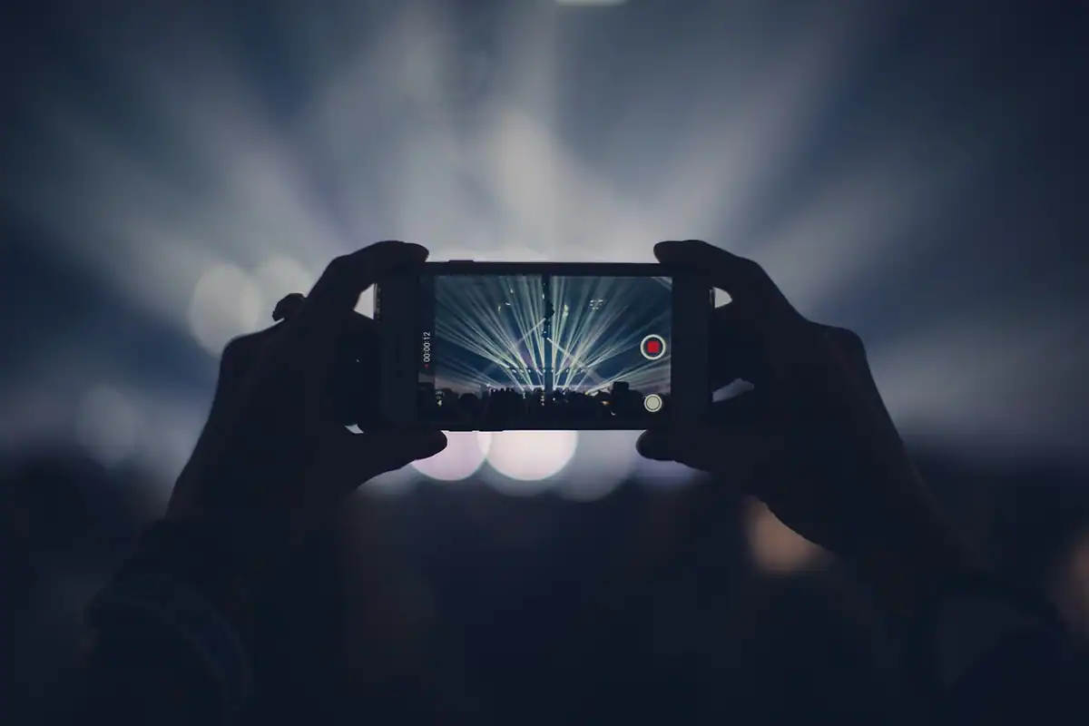 Telefon ținut în mâini în timp ce filmează o scenă cu lumină puternică