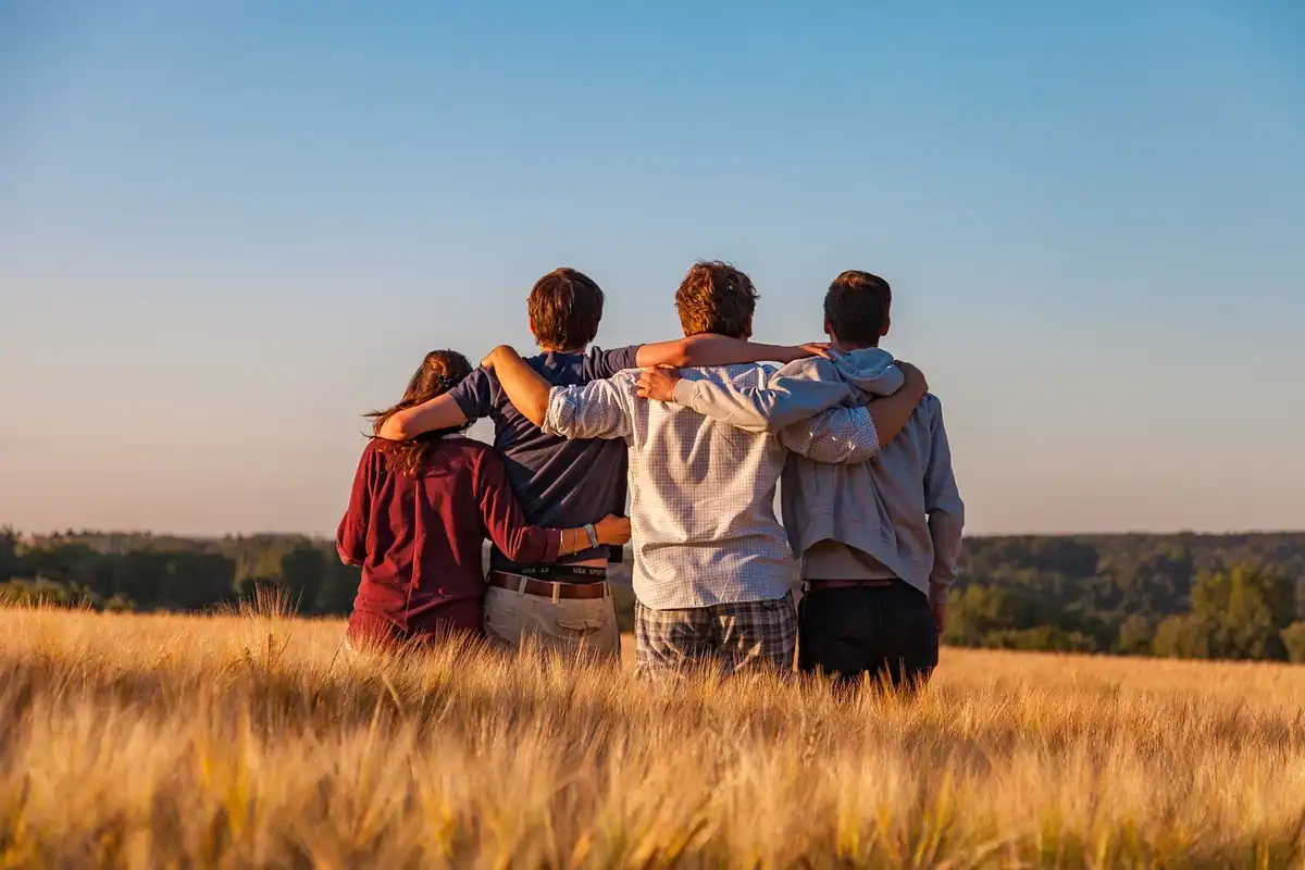 Grup de prieteni care discută în jurul unei mese, comunitate adunată într-un grup de Facebook al firmei