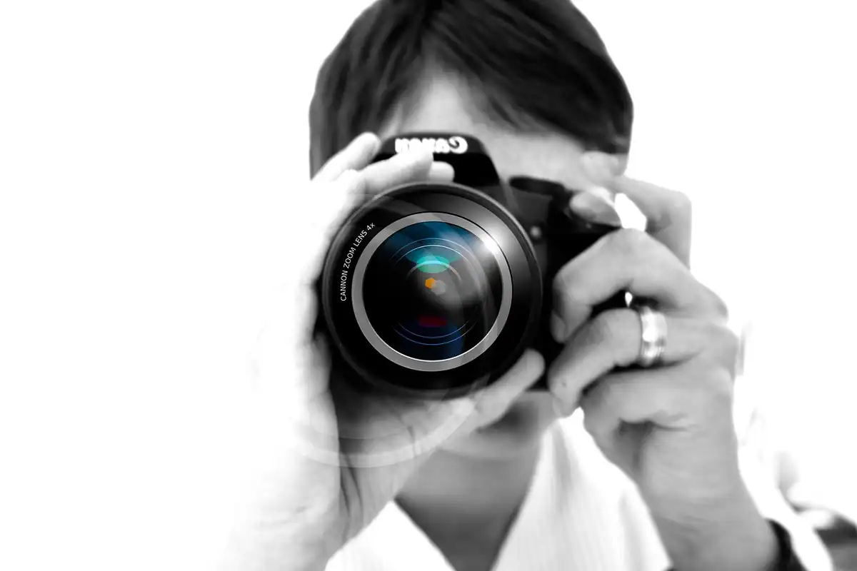 Mâinile unui fotograf cu aparatul foto, pregătind imaginile pentru reclame online