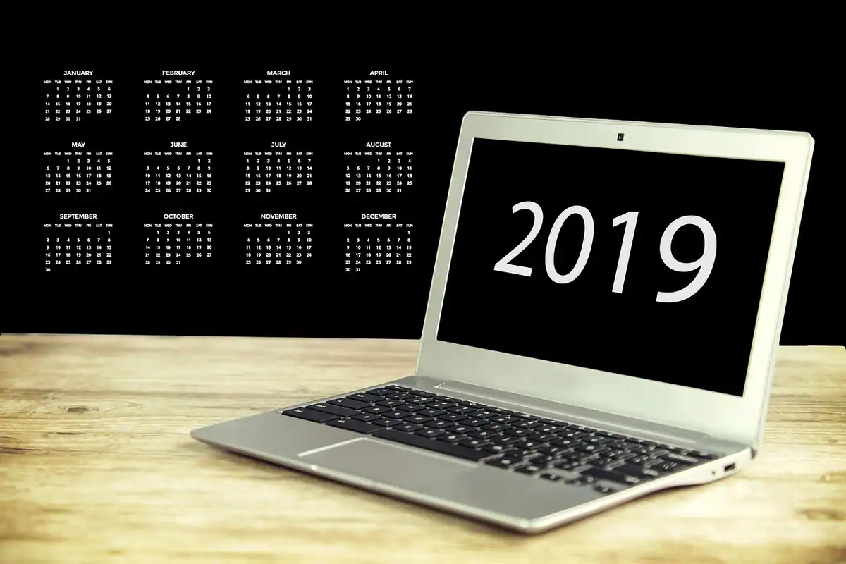 Calendar lunar, laptop și o plantă pe birou, analiza lunară a rezultatelor conținutului