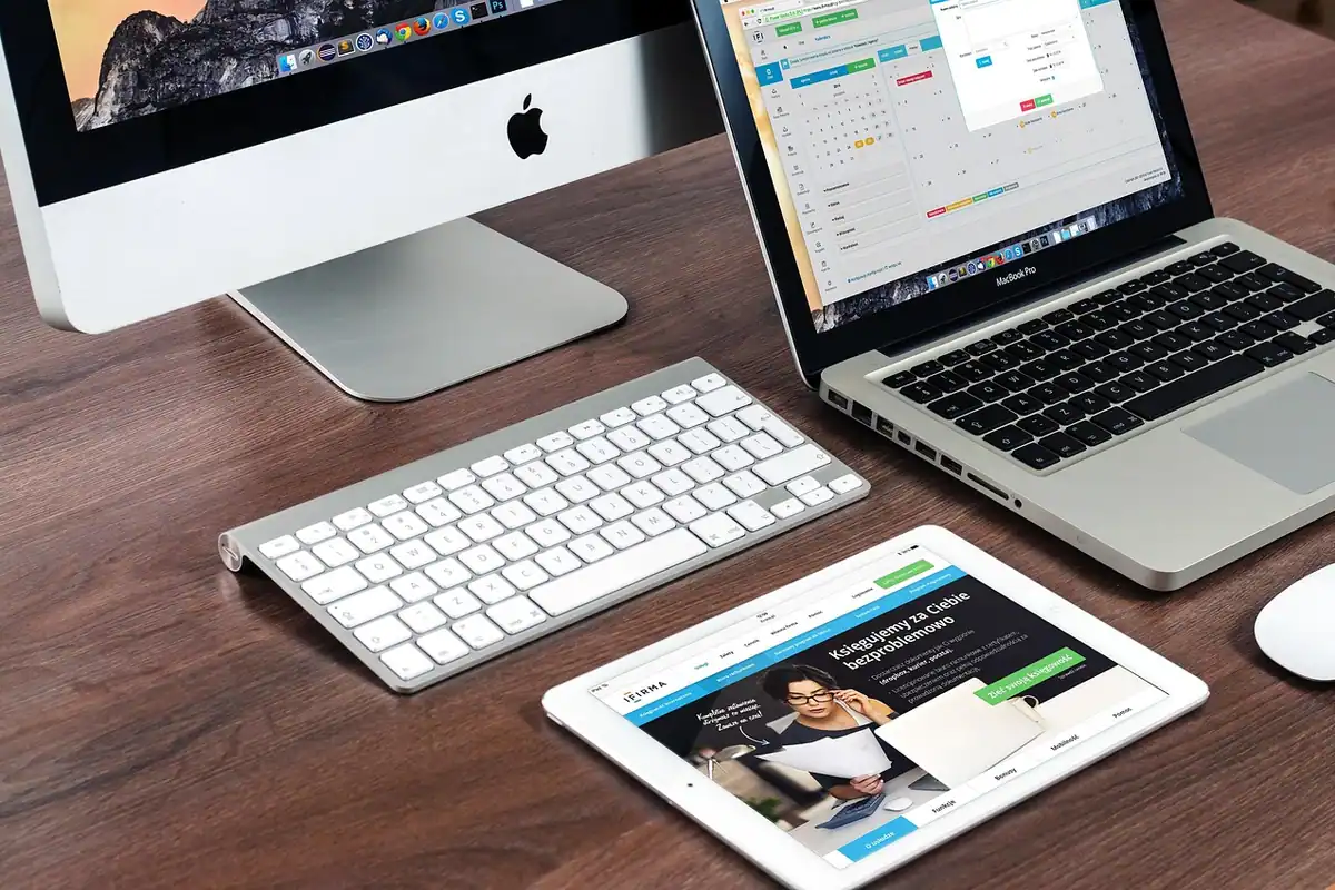 Calculator iMac, laptop, tastatură și tabletă cu o pagină web pe birou