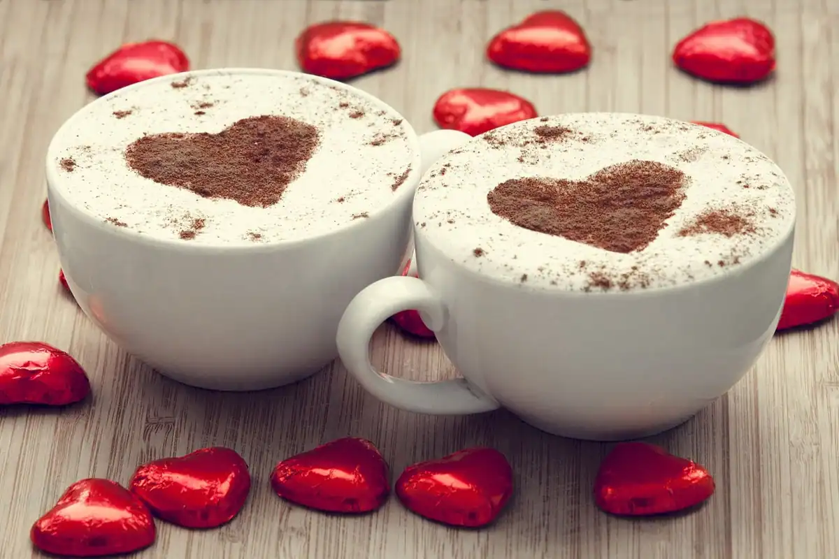 Două cești de cafea și un caiet pe un birou comun, colaborarea cu un redactor extern