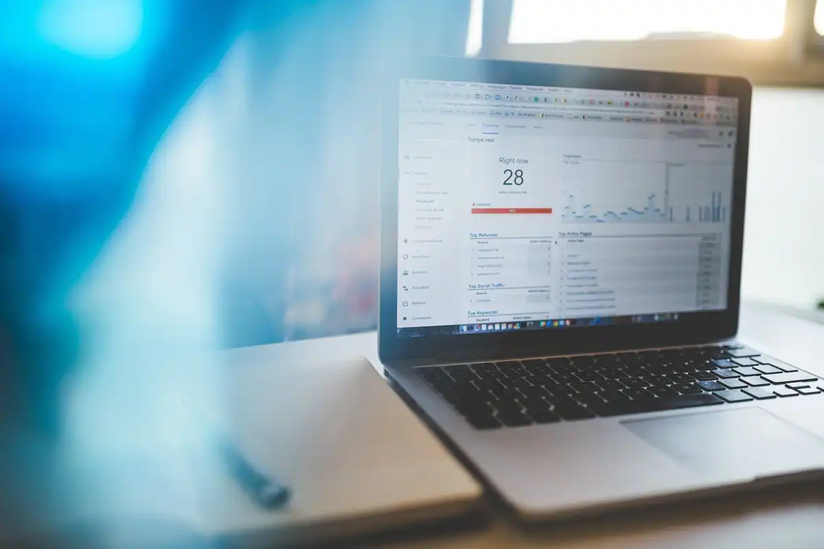 Laptop cu un tablou de statistici pe ecran, în lumină albastră