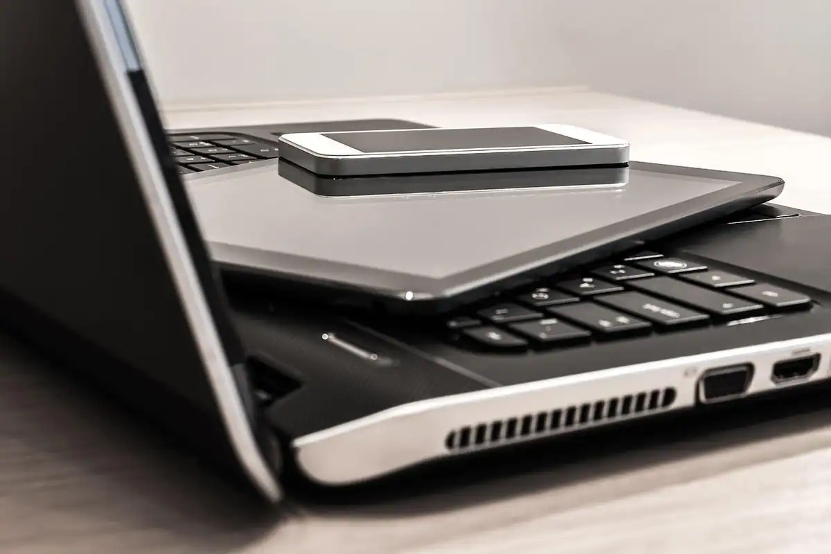 Laptop și telefon așezate pe un birou alb