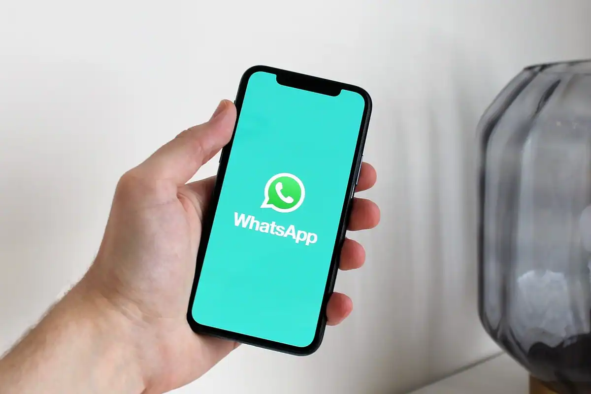 Smartphone pe un birou cu aplicația de chat deschisă, lângă un caiet, pentru WhatsApp Business